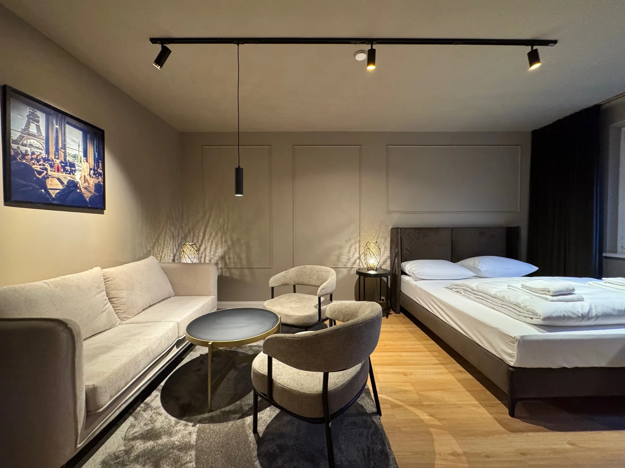 Business Suite Leipzig — Schlafzimmer 1 mit Sesselecke und Schreibtisch