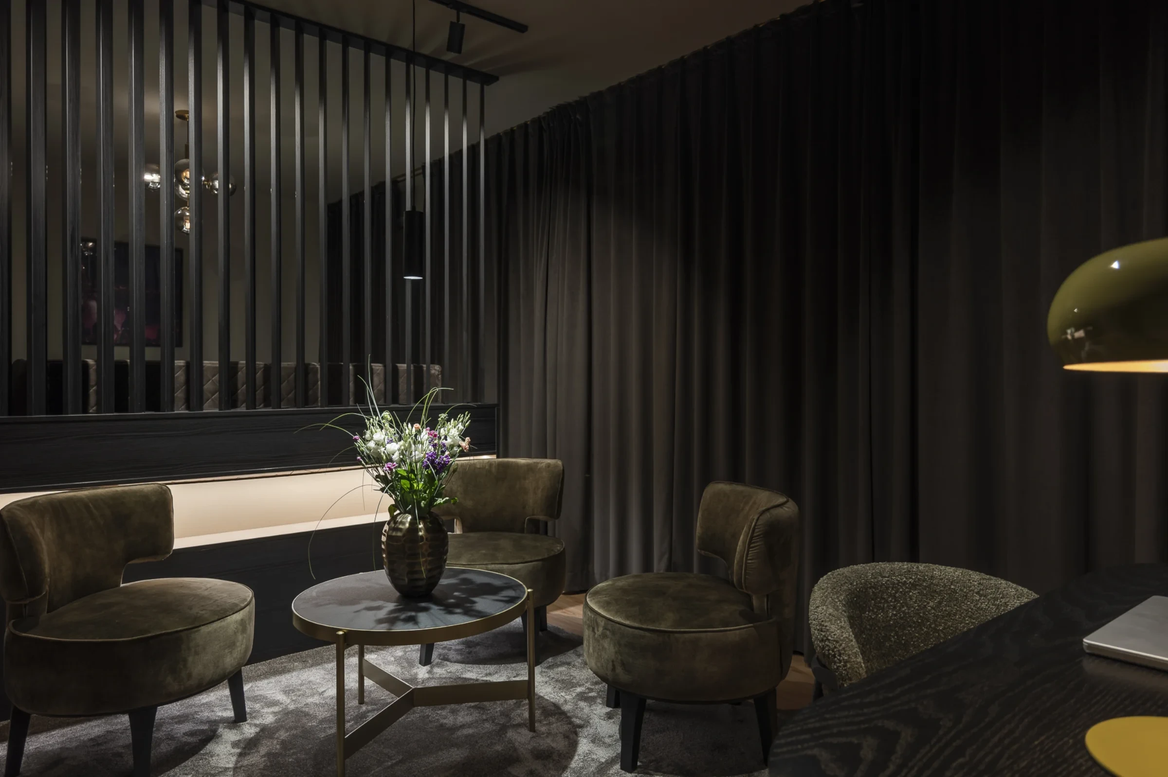 Leipzig Suites Lounge mit Samt-Sesseln und Lamellenwand